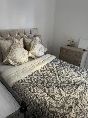 a bedroom with a large bed with pillows on it at Le Nid Doré, Appartement Chic au Centre de Meknès in Meknès