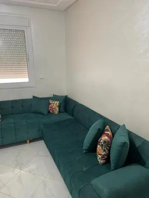 a green couch in a living room with a window at Le Nid Doré, Appartement Chic au Centre de Meknès in Meknès