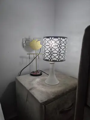 a table with a lamp on top of a dresser at Le Nid Doré, Appartement Chic au Centre de Meknès in Meknès
