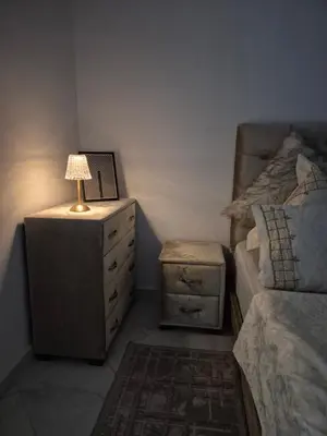 a bedroom with a bed and a dresser with a lamp at Le Nid Doré, Appartement Chic au Centre de Meknès in Meknès