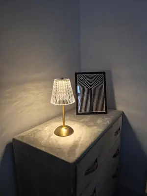 a lamp on top of a dresser with a picture at Le Nid Doré, Appartement Chic au Centre de Meknès in Meknès