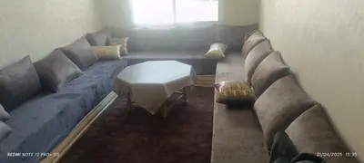 a living room with a couch and a table at apartment raha in Oulad Akkou