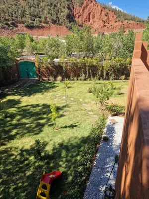 a backyard with a garden with trees and a hill at Villa Jenate Serenitée et paix in Timalizèn