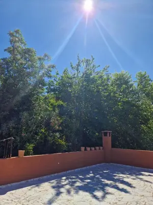 a sun shining over a fence with trees in the background at Villa Jenate Serenitée et paix in Timalizèn
