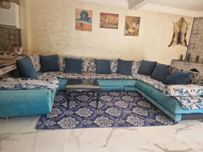 a living room with a blue couch in a room at Villa Jenate Serenitée et paix in Timalizèn