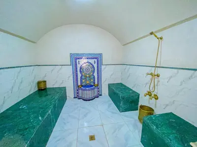 a bathroom with two green benches and a painting on the wall at Villa de luxe à louer Marrakech in Ourika