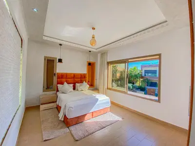 a bedroom with a white bed and a window at Villa de luxe à louer Marrakech in Ourika