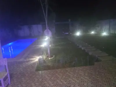 a cross in a yard at night with lights at Villa tagmouti in Aghmat