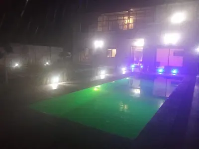 a house with a swimming pool at night with lights at Villa tagmouti in Aghmat