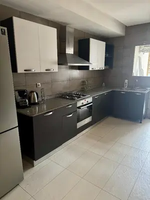 a kitchen with black and white cabinets and appliances at Luxueux Appartement Prestigia avec Wifi 100 M in Fès