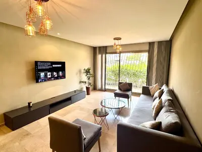 a living room with a couch and a tv at Luxueux Appartement Prestigia avec Wifi 100 M in Fès