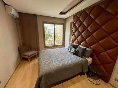 a bedroom with a large bed and a window at Luxueux Appartement Prestigia avec Wifi 100 M in Fès