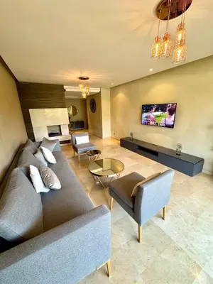 a living room with a couch and a tv at Luxueux Appartement Prestigia avec Wifi 100 M in Fès