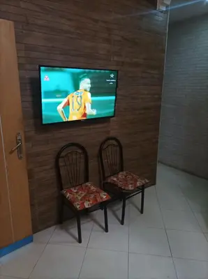 two chairs and a flat screen tv on a wall at Appartement La Joie in Oulad Akkou
