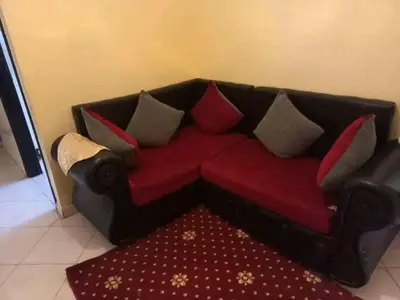 a black couch with pillows on a red rug at العنوان حي المقاومة بلوك دال رقم 389 مكرر ورزازات in Oulad Akkou