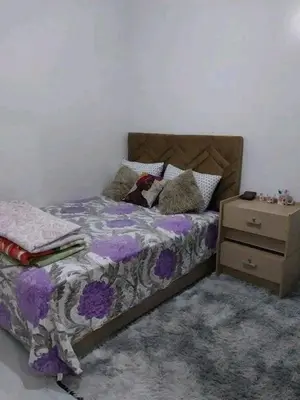 a bedroom with a bed and a night stand at العنوان حي المقاومة بلوك دال رقم 389 مكرر ورزازات in Oulad Akkou