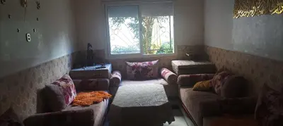 a living room with couches and a large window at La joie in Oulad Akkou