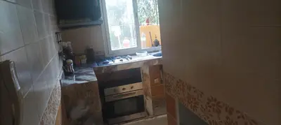 a small kitchen with a stove and a window at La joie in Oulad Akkou