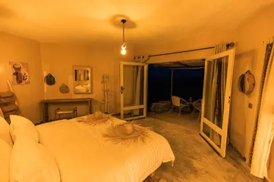 a bedroom with a bed and an open door to a patio at Dunes Clave in Hassilabied