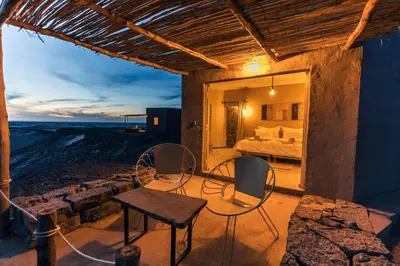 a bedroom with a bed and a table and chairs at Dunes Clave in Hassilabied