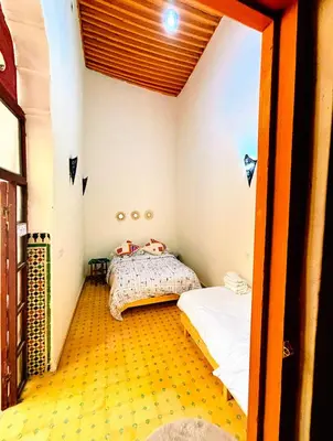 a bedroom with two beds in a room with yellow floors at Riad Ayoub Fes in Fès