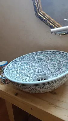 a blue and white bowl sitting on a wooden table at Riad Ayoub Fes in Fès