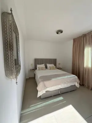 a bedroom with a bed in a white room at Cabo vip in Oulad Akkou