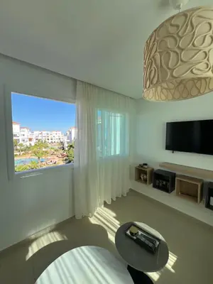 a living room with a large window and a television at Cabo vip in Oulad Akkou