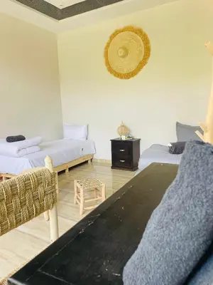 a living room with two beds and a couch at Villa MSHolidays 3 palmiers avec piscine marrakech in Marrakech