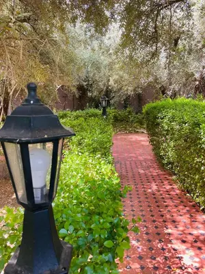 a street light next to a red brick path at Villa MSHolidays 3 palmiers avec piscine marrakech in Marrakech
