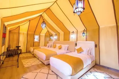 a bedroom with two beds in a large room at Merzouga Luxurious Stay in Merzouga