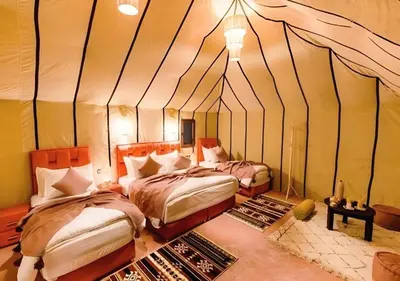 two beds in a room with a tent at Merzouga Luxurious Stay in Merzouga