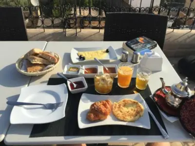 a table with plates of food and drinks on it at Riad Sabah in Fès