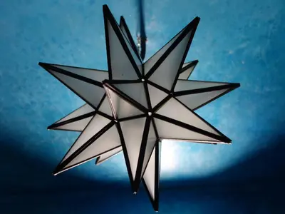 a hanging star chandelier with a blue background at Riad Sabah in Fès