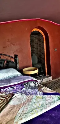 a bedroom with a bed with a brick fireplace at Camp sahara in Oulad Akkou