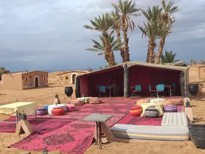 a tent in the middle of a desert with palm trees at Camp sahara in Oulad Akkou
