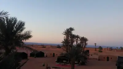 a view of a desert with palm trees and houses at Camp sahara in Oulad Akkou