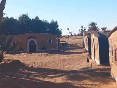 a group of huts in the desert with a painting on it at Camp sahara in Oulad Akkou