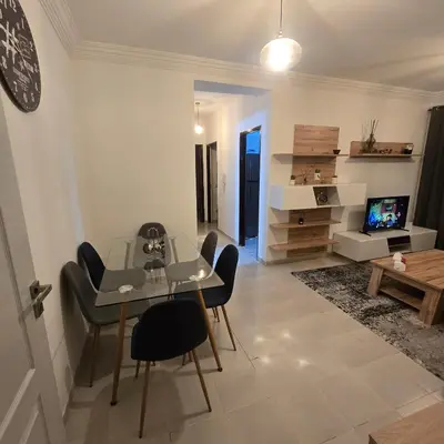 a living room with a table and chairs and a television at Appartement Confortable à Chouiter in Chouiter