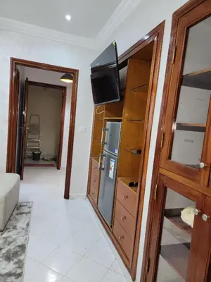 a living room with a refrigerator and a tv on a wall at Studio bahaji in Oulad Akkou