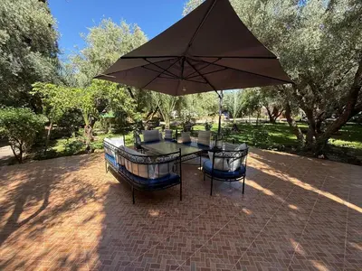 a table and two chairs under an umbrella at Beautiful peaceful haven with free breakfast in Aghmat