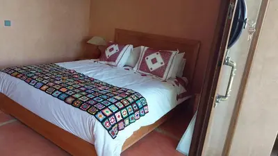 a bedroom with a large bed with white sheets and pillows at Beautiful peaceful haven with free breakfast in Aghmat