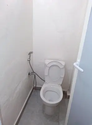 a bathroom with a white toilet in a stall at Studio meublé calme in Oulad Akkou