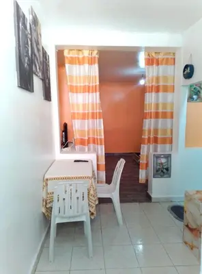 a living room with a table and a chair at Studio meublé calme in Oulad Akkou