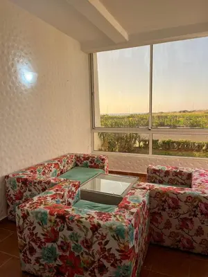 a living room with a couch and a large window at إقامات أهلا قرب مرجان طريق الرباط in Oulad Akkou