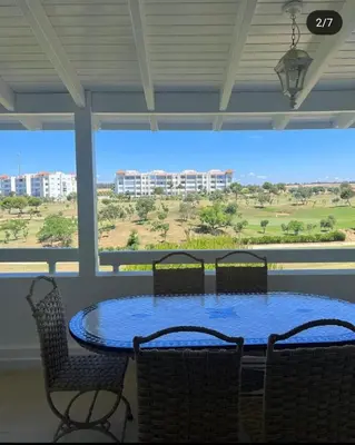 a patio with a table and chairs and a large window at إقامات أهلا قرب مرجان طريق الرباط in Oulad Akkou