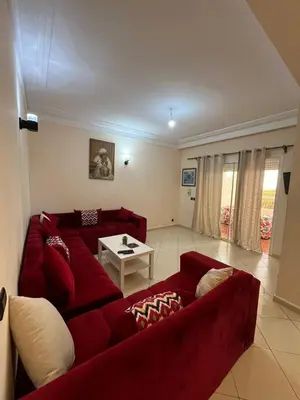 a living room with a red couch and a table at إقامات أهلا قرب مرجان طريق الرباط in Oulad Akkou