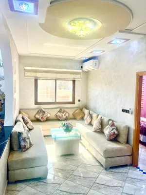 a living room with a couch and a table at Apparemment 3 chambre in Oulad Akkou