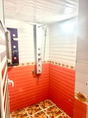 a shower in a bathroom with red walls at Apparemment 3 chambre in Oulad Akkou
