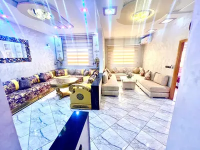a large living room with couches and a table at Apparemment 3 chambre in Oulad Akkou